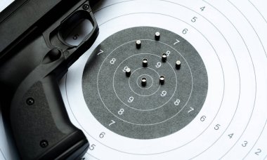 Siyah havalı tüfek saçma tabancası, çelik metal saçma mermilerinin yanında, kağıt bir hedefin üzerine bırakılmış. Havalı tüfekler, spor, atış yarışması basit eğitim kavramları, hiç kimse, hiç kimse
