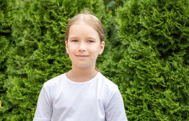 Avrupalı genç bir ilkokul çocuğu gülümsüyor, doğal mutlu çocuk portresi, yüzü yakın çekim, kameraya bakan bir kişi, kopyalama alanı. Gerçek insan yaşam tarzı.