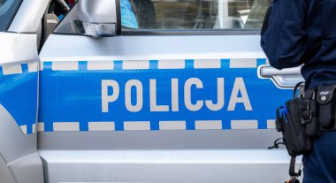 Mavi Polonyalı polis aracı ve bir polis, polis, polis arabası yan görev, yakın çekim. Polonya acil servisleri basit kavram, bir kişi, editoryal resim