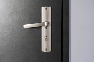 Simple modern metal door handle on a brand new apartment door, front view interior side object detail, closeup, nobody no people Real estate block of flats safety security protection abstract concept clipart