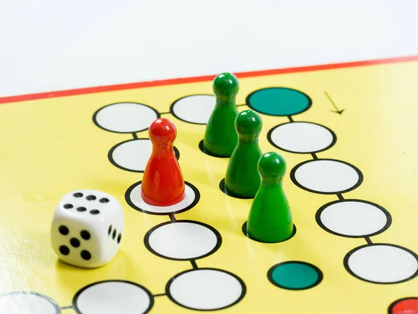 A classic generic board game with colorful game pieces and game dice on the board, object closeup detail, nobody. Playing a simple game, toys for kids, theory, rules abstract concept, no people