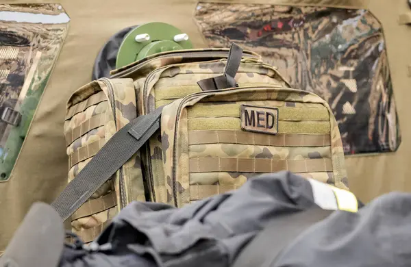A professional military grade medkit, infantry army med kit, bag of medical supplies and equipment green camo bag closeup, nobody. War, warzone medics, help for the injured soldiers simple concept