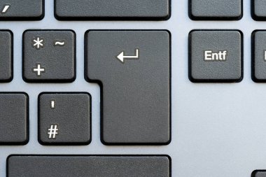 Modern bir bilgisayar klavyesinde Enter tuşunun yakın plan görüntüsü, bir eylemi tamamlamak, bir sohbet mesajı göndermek, bir iş için başvurmak, doğrulama, tamamlama ve girdi basit soyut konsepti kabul etmek