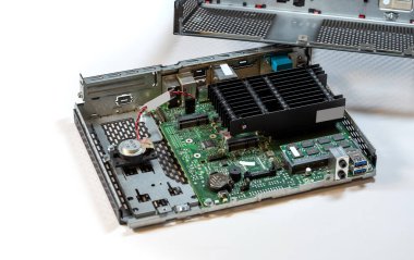 Opened passively cooled computer terminal, displaying showing internal parts, components. Motherboard, heatsink, and various connectors on display, desktop PC service and repair abstract concept clipart