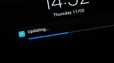 Devam eden işletim sistemi güncellemesini gösteren işlem çubuğu genel bir mobil cihaz, akıllı telefon, tablet, hiç kimse, ekran görüntüleme makro detay yakın çekim görüntüsü. Yazılım soyut kavramı güncelleniyor