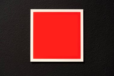 Boş boş kırmızı kare işareti, binanın içinde, karanlık bir ofis duvarında asılı. Şablon, model, logo sembolü için kopyalama alanı, uyarı işareti yer tutucu çerçevesi, sınır, hiç kimse