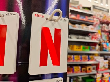 Netflix marka logo hediye kartları bir markette satılıyor, abonelik kuponu kodları fatura kartı konseptiyle satılıyor, nesne detayı, kimse içeriden alışveriş yapmıyor.