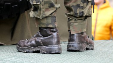 Görev başındaki tanınmayan piyade asker botlar, kamuflaj üniforması, metal bir yüzey üzerinde duran, detaylı çekim. Ordu askerleri savaş operasyonları basit soyut konsept sembolü, haber çekimi