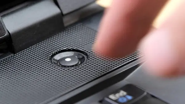 stock image Man's finger reaching to press a generic laptop computer power button, about to turn the device on or off, hovering over the power key, object closeup detail, one person, simple abstract concept