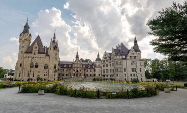 Moszna Şatosu, Polonya 'nın Opole kenti yakınlarındaki 18. yüzyıldan kalma geniş sarayın ön cephe girişinin, panorama çeşmesinin, karışık stil mimarisinin tam dış görüntüsü.