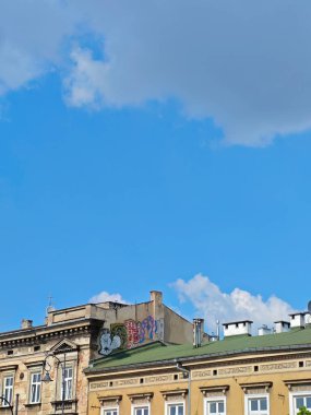 Krakow apartmanının çatısı, eski şehir merkezinin çatıları ve bulutlu boş mavi gökyüzü boş dikey poster arka planı, hiç kimse, gündüz vakti, güneş ışığı