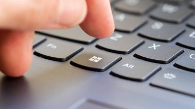 Windows 11 10 sistem tuşuna basan adam yeni bir modern dizüstü bilgisayar klavye parmak kapatma detayı, bir kişinin eli, işletim sistemi işletim sistemi tuşuna yakın basılıyor