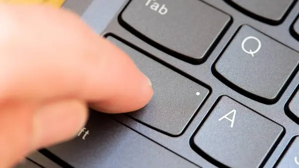 stock image Man pressing the Capslock key on a modern laptop computer keyboard, capital letters simple concept, finger pressing the CapsLk key up close detail. Online arguments, shouting in text abstract symbol