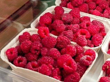 Markette eko-dost kağıt ambalajlı taze ahududular, satılık olgun kırmızı meyveler, sağlıklı organik meyveler, yaz hasadı, tarım ürünleri, canlı renkler, hiç kimse.