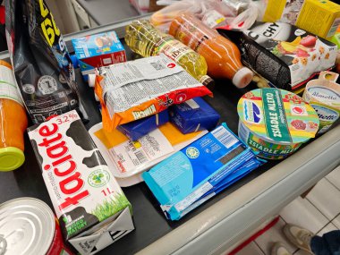 Marketteki bakkal kasalarında çeşitli ürünler süt ürünleri içecekler ve paketlenmiş gıda öğeleri taşımacılık bandı süpermarket kontrolleri için gerekli malzemelerin yakın çekimleri