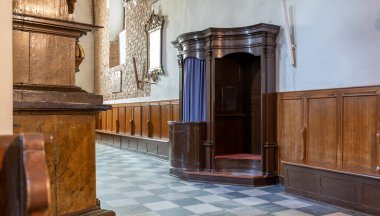 Lone empty wooden confession booth in traditional church interior, empty vacant confession stall, nobody, no people, classic architecture, catholic confessional, nobody present sin and penance concept clipart