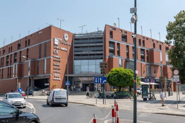 Polonya 'nın Opole kentindeki Solaris alışveriş merkezinin dış görünüşü, popüler perakende markalar, kırmızı tuğla cepheli modern şehir mimarisi, cadde, araba ve önünde insanların yer aldığı