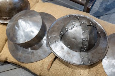 Çuval bezi arka planında yeniden inşa edilmiş ortaçağ metal miğferleri, perçinlenmiş demirle tarihi zırh tasarımı, ortaçağdan kalma antik savaş başlıkları, antika koruma ekipmanları konsepti.