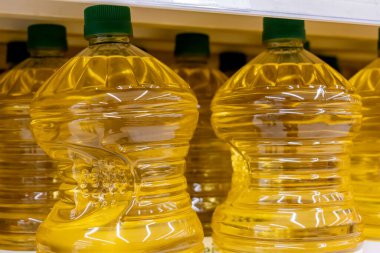 Büyük plastik markasız 5 litre 1 kız şişesi süpermarket raflarında pişirme yağı, altın kanola yağı kapları, yenilebilir yağ ambalajları, perakende sebze yağı ürünleri, insan yok.