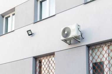 Açık hava klima yoğunlaştırıcı ünitesi modern bina cephesine monte edildi, pencerelerin yanındaki duvarda havalandırma ve ısıtma sistemi, iklim kontrol ekipmanları sistemi kurulumu dış kapama, hiç kimse