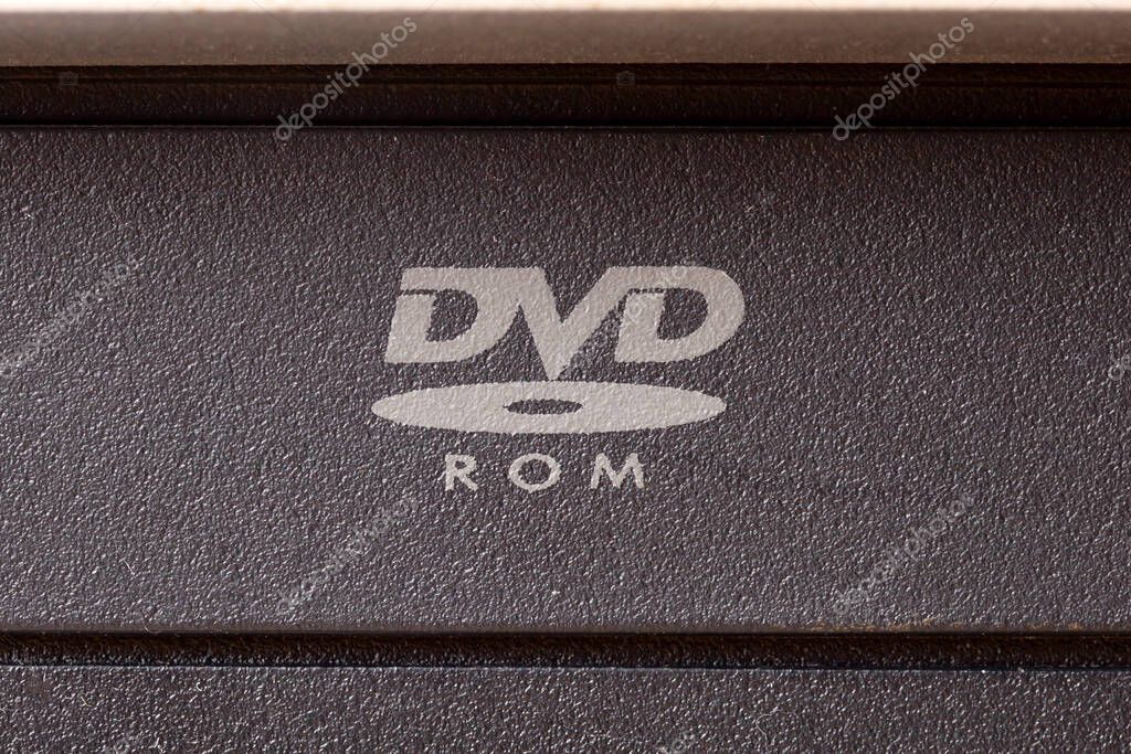Macro closeup of a DVD ROM logo symbol on a PC CD disk drive front panel optical media logo data reading hardware concept, old media formats, older obsolete computer storage components concept, nobody