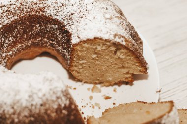 The baked dessert is a round cupcake sprinkled with powder.