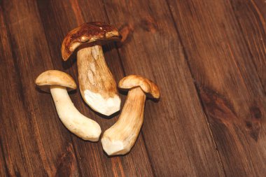 Kahverengi tahtalardan yapılmış bir masada yemek için hazırlanan Boletus edulis..