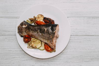 Fırında sebzeyle pişirilmiş kırmızı balık alabalığı..