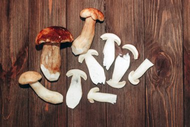 Kahverengi tahtalardan yapılmış bir masada yemek için hazırlanan Boletus edulis..