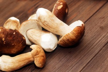 Kahverengi tahtalardan yapılmış bir masada yemek için hazırlanan Boletus edulis..