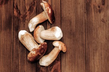 Kahverengi tahtalardan yapılmış bir masada yemek için hazırlanan Boletus edulis..