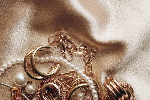 Women\'s jewelry, gold chain, trendy jewelry on a silk background.