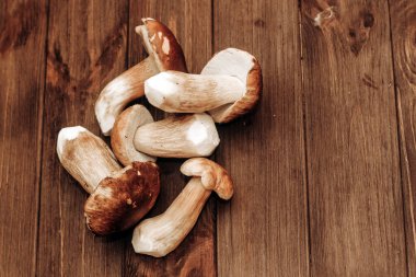 Kahverengi tahtalardan yapılmış bir masada yemek için hazırlanan Boletus edulis..