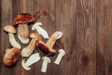 Kahverengi tahtalardan yapılmış bir masada yemek için hazırlanan Boletus edulis..