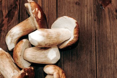 Kahverengi tahtalardan yapılmış bir masada yemek için hazırlanan Boletus edulis..