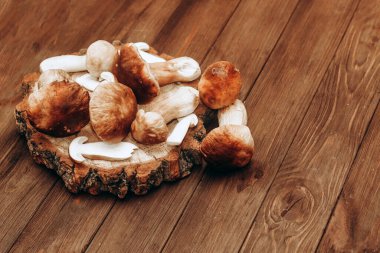 Kahverengi tahtalardan yapılmış bir masada yemek için hazırlanan Boletus edulis..