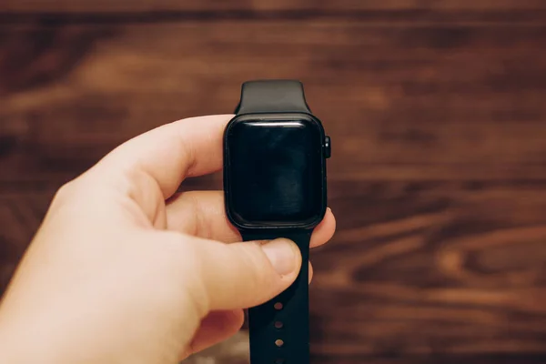 Black technological smart watch in hand.