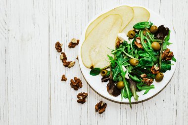 Armutlu salata, otlar, roka, prosciutto, peynir, yeşil zeytin ve fındık..