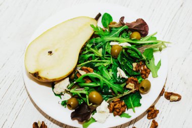 Armutlu salata, otlar, roka, prosciutto, peynir, yeşil zeytin ve fındık..