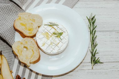 Masada zeytinyağı ve peynirli ekmek dilimleri var..