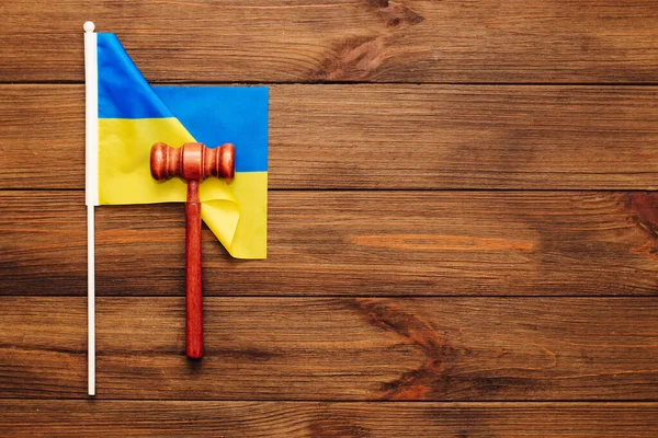 Tahta zemin üzerinde yargıç tokmağı olan Ukrayna mavisi sarı bayrağı.