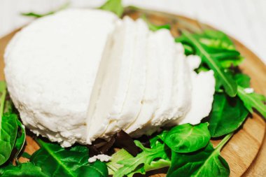 Sülüguni ahşap bir tahtanın üzerinde otlarla peynir turşusu kurdu..