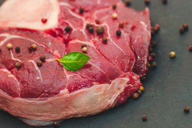 Taze et. Kemik ossobuco 'sunda büyük bir biftek. Siyah arka planda bir filiz biberiye..