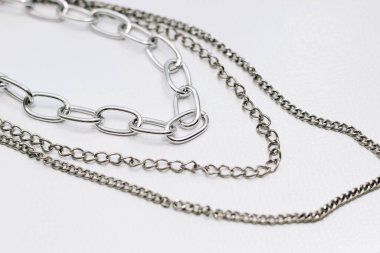 Açık arkaplanda farklı gümüş metal zincirler.