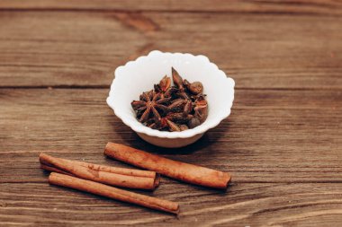 Spices anise, pepper, cumin, cumin, ginger in bowls on a wooden table.