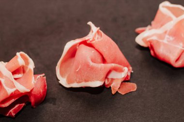 Kara tahtada kurutulmuş domuz jambonu jambonu parçaları..