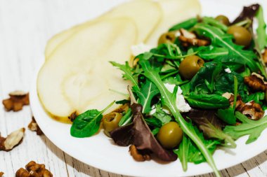 Armutlu salata, otlar, roka, prosciutto, peynir, yeşil zeytin ve fındık..