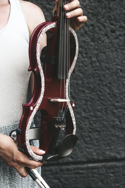 stock image A fragment of an electric violin, a violin in the hands of a musician's girl