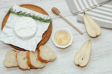 Ekmek arası peynirli baget ekmek ve masada ballı biberiye..