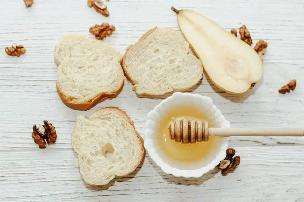 stock image Pieces of ripe pear with croutons with honey on the kitchen table.